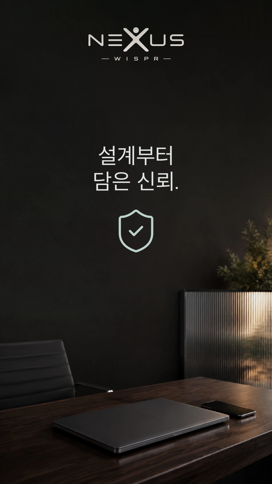 방패 위의 Nexus Wispr 로고와 ‘설계부터 담은 신뢰’ 문구. 책상에는 닫힌 노트북과 휴대폰이 있습니다.
